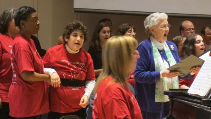 Composer, conductor, and arranger Alice Parker joins Joyful Noise and Collegium members in song. At the piano is the associate director of Joyful Noise, Cathy Sonnenberg; the group’s co-founder, Beth Fromm, stands second from left.