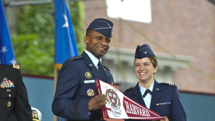The force is with the U.S. Air Force as General McDew receives a Harvard banner from Second Lieutenant Madison Coveno.