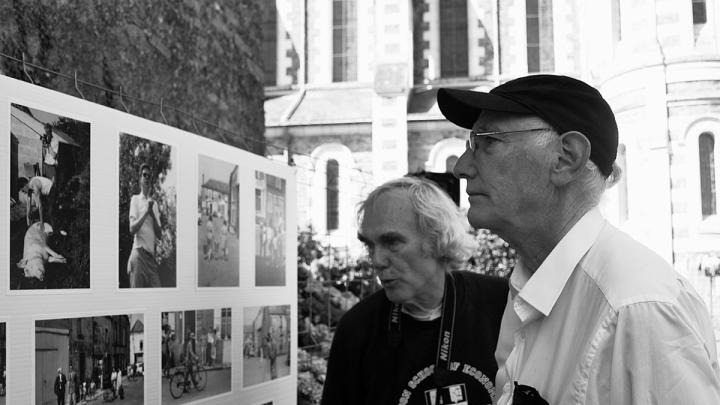 Peter Winship (left) and Bill Christian examine photographs recalling their days as student researchers in the village of Chanzeaux, under the tutelage of the late Laurence Wylie.