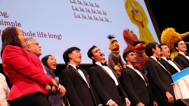 The Harvard Krokodiloes sing with Muppets and Harvard and Sesame Street leaders. 